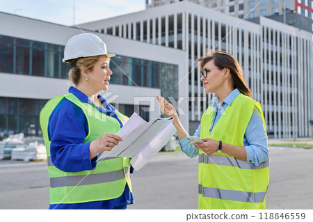 Two confident women talking working on construction of residential office building 118846559