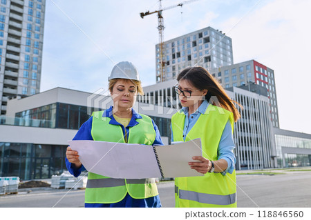 Two confident women talking working on construction of residential office building 118846560