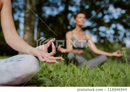 Medium close up of unrecognizable manicured female hand during meditation in park 118846944