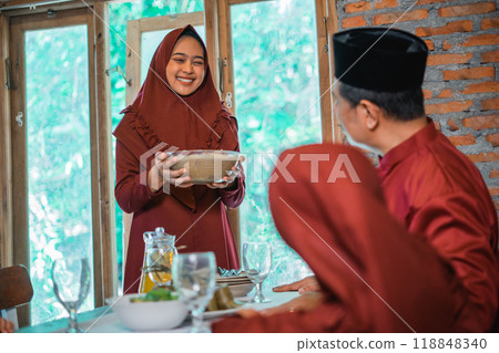 Asian Muslim mom brings a bowl of compote for the family's iftar Asian Muslim mom brings a bowl of compote for the family's iftar 118848340