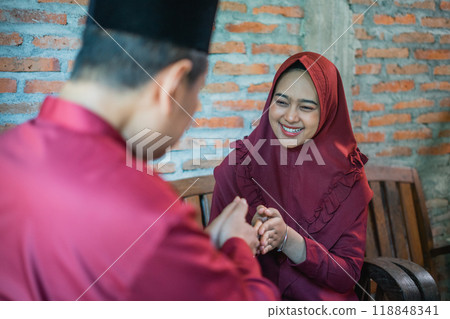 Young Muslim couple forgive each other on Eid at home Young Muslim couple forgive each other on Eid at home 118848341