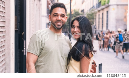 Happy couple standing together in city during daytime Happy couple standing together in city during daytime 118848415