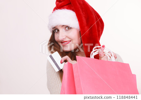 woman in Christmas hat holds credit card and shopping bags. woman in Christmas hat holds credit card and shopping bags. 118848441