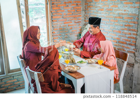 Asian Muslim mother serves food for family meal at home 118848514