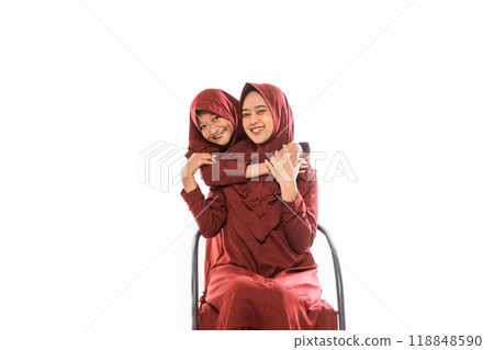 Smiling little girl and Muslim mother embracing her mother from behind Smiling little girl and Muslim mother embracing her mother from behind 118848590