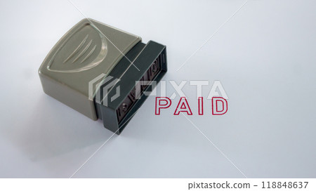 Close up Rubber stamp with paid word on white paper background. 118848637