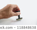 The Asian hand holding rubber stamp on white paper background. 118848638