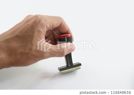 The Asian hand holding rubber stamp on white paper background. 118848638