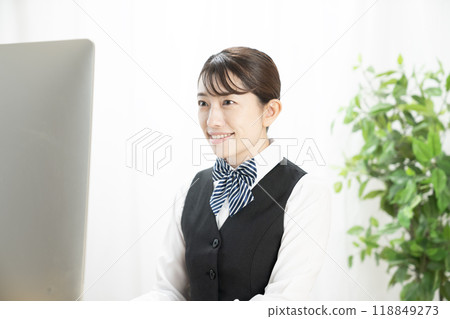 Smiling businesswoman looking at a computer screen Smiling businesswoman looking at a computer screen 118849273