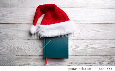 Festive Santa Hat on a Green Book for Cozy Holiday Reading 118849333