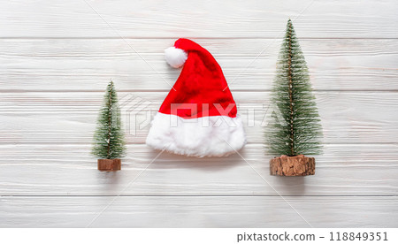 Miniature Christmas Trees with Santa Hat on White Wooden Background for Festive Decor 118849351