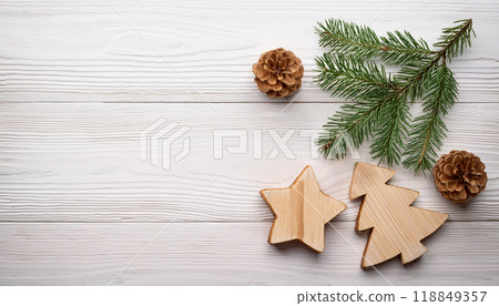 Wooden Christmas Ornaments with Pine Cones and Evergreen Branch on White Wooden Background for Festive Decor Wooden Christmas Ornaments with Pine Cones and Evergreen Branch on White Wooden Background for Festive Decor 118849357