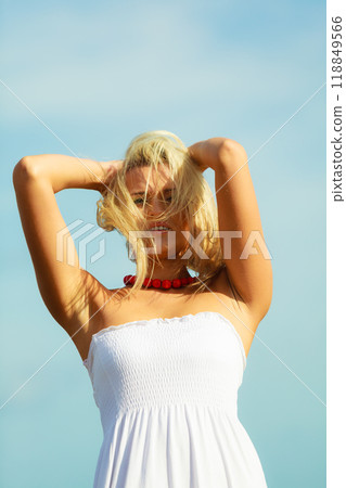 Beautiful woman wearing white dress, sky background Beautiful woman wearing white dress, sky background 118849566