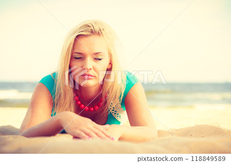 Woman lying on sandy beach relaxing during summer 118849589