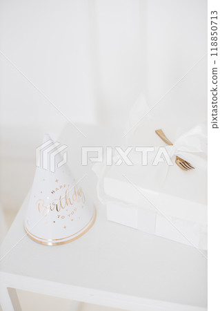 Elegant birthday celebration setup with gift and party hat Elegant birthday celebration setup with gift and party hat 118850713
