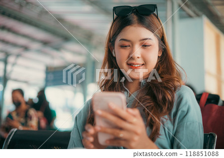 A Young Woman is Enjoying her Mobile Experience while Relaxing in a Modern Airport Lounge 118851088