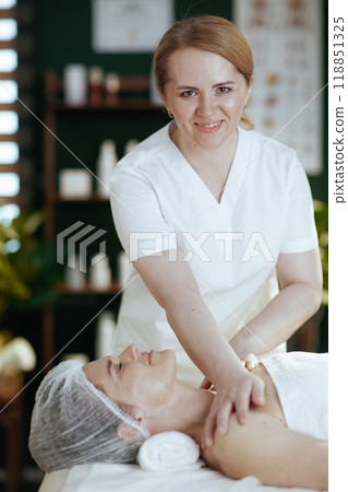 massage therapist in spa salon massaging clients shoulder 118851325