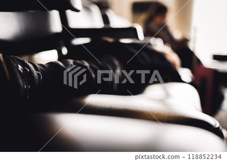 Selective focus on the feet of a child asleep on a row of chairs in an airplane terminal Selective focus on the feet of a child asleep on a row of chairs in an airplane terminal 118852234