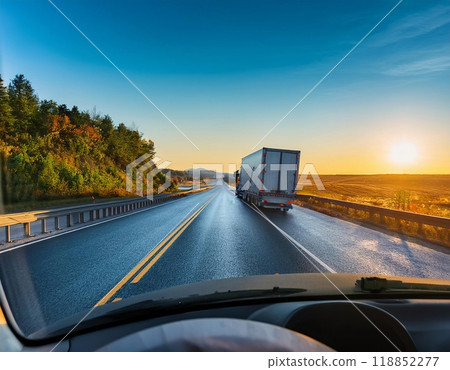 A truck driving along a scenic highway at sunset with clear skies and lush surroundings. Generative AI 118852277
