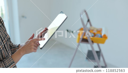 Close up of female holding tabletPC with color selecting right wall color in new house. Home renovation. Close up of female holding tabletPC with color selecting right wall color in new house. Home renovation. 118852563