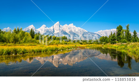 Breathtaking view of the Grand Teton Mountain Range reflecting in the calm waters of the Snake River, captured in Wyoming, United States Breathtaking view of the Grand Teton Mountain Range reflecting in the calm waters of the Snake River, captured in Wyoming, United States 118853816