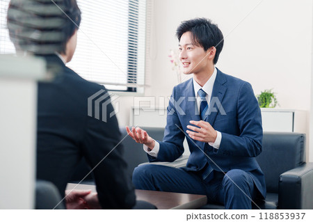 A businessman in a suit negotiating with a client 118853937