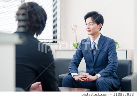 A businessman in a suit negotiating with a client 118853938