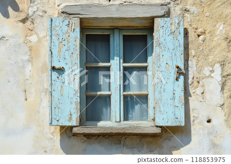Rustic blue window with wooden shutters on an aged stone wall in a quaint countryside setting 118853975