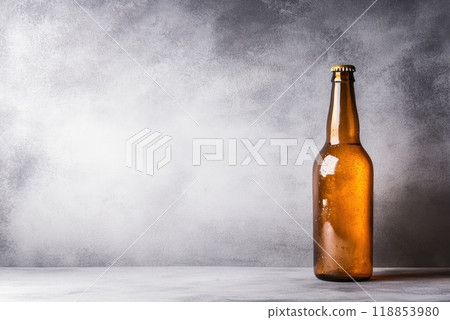 A single amber beer bottle stands on a minimalist gray backdrop showcasing its refreshing appeal and inviting coolness 118853980