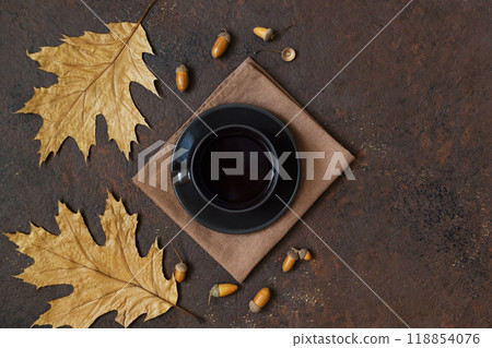 Black coffee on brown background with copy space. Acorn coffee in black cup with autumn leaves. Top view, flat lay. Black coffee on brown background with copy space. Acorn coffee in black cup with autumn leaves. Top view, flat lay. 118854076