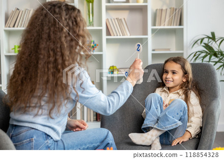 Female speech therapist with long hair working with a cute girl 118854328