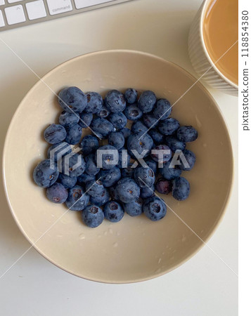 Fresh blueberries in white plate close-up, background 118854380