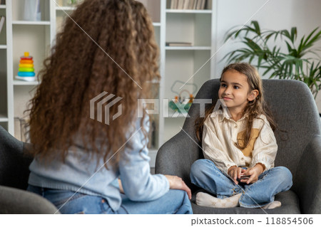 Long-haired female speech therapist having a session with a girl Long-haired female speech therapist having a session with a girl 118854506