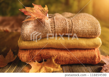 Stacked wool autumn sweaters on wooden background Stacked wool autumn sweaters on wooden background 118854590