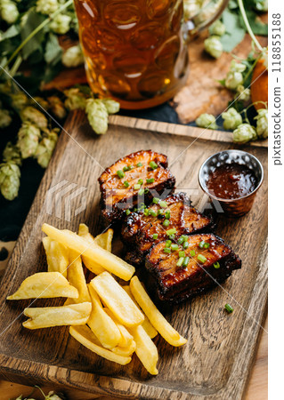 Barbecue ribs with fries and sauce served on a wooden platter. Perfect pub food for beer pairing Barbecue ribs with fries and sauce served on a wooden platter. Perfect pub food for beer pairing 118855188