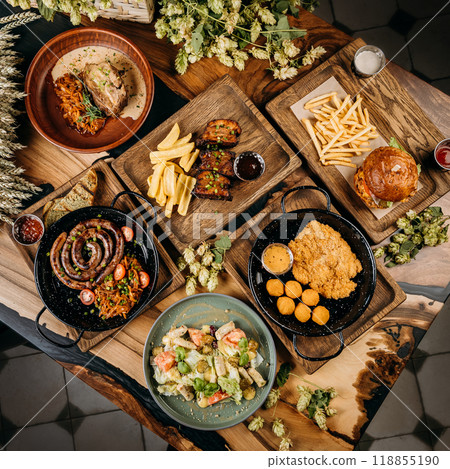 Top view of assorted gourmet dishes with sausage, pork ribs, salad, schnitzel, and burger with fries 118855190