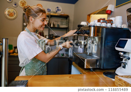 Barista at Work Skillfully Crafting the Perfect Coffee Experience in a Warm, Cozy Cafe Barista at Work Skillfully Crafting the Perfect Coffee Experience in a Warm, Cozy Cafe 118855489
