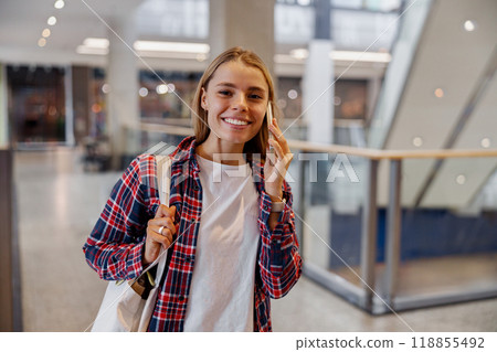 A Cheerful Woman Smiling Happily in a Modern Urban Shopping Center Filled with Life A Cheerful Woman Smiling Happily in a Modern Urban Shopping Center Filled with Life 118855492