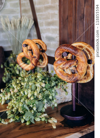 Traditional Bavarian pretzels displayed on stands with fresh hops, Oktoberfest and German cuisine Traditional Bavarian pretzels displayed on stands with fresh hops, Oktoberfest and German cuisine 118855594