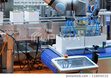 technology automated robotic arm handling product packaging to cardboard boxes on a conveyor belt in modern industrial production line in factory. innovation logistic and production line system 118858132
