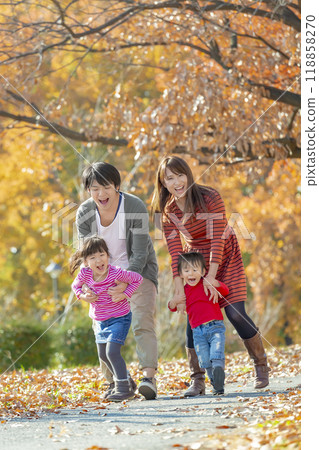 A family of four playing in the autumn leaves park A family of four playing in the autumn leaves park 118858270