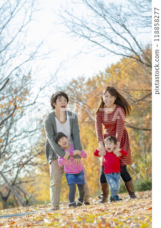 A family of four playing in the autumn leaves park A family of four playing in the autumn leaves park 118858277