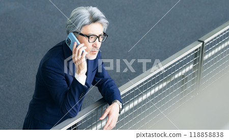Executive man talking on smartphone in lobby 118858838