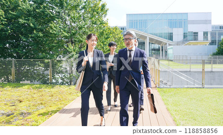 A group of business people of all ages walking outdoors A group of business people of all ages walking outdoors 118858856