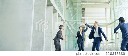 Group of business people dancing in a lobby Group of business people dancing in a lobby 118858880