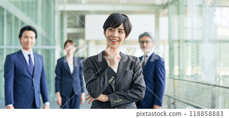 一位女商人高興地微笑著,被同事包圍 一位女商人高興地微笑著,被同事包圍 118858883