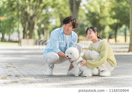 A dog-loving family walking their dog, father, daughter, parent and child A dog-loving family walking their dog, father, daughter, parent and child 118858904