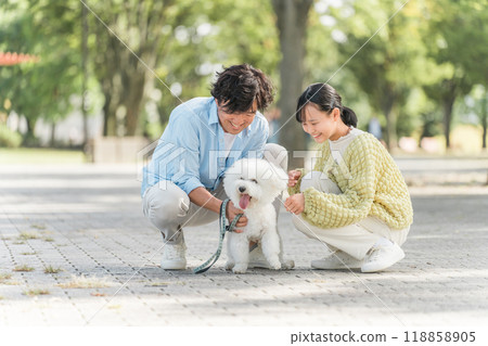 A dog-loving family walking their dog, father, daughter, parent and child 118858905