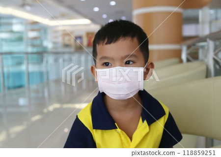 An Asian boy about five years old wearing a mask for prevent respiratory diseases. An Asian boy about five years old wearing a mask for prevent respiratory diseases. 118859251