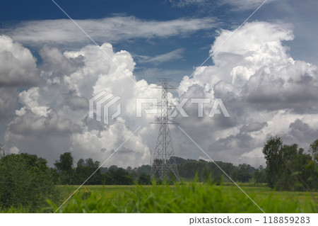 High-voltage electric towers between the cities stand in rice fields, with white clouds in the sky on a clear day. High-voltage electric towers between the cities stand in rice fields, with white clouds in the sky on a clear day. 118859283